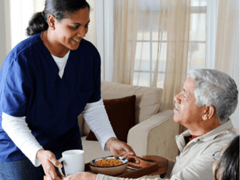 A active senior couple smiling and walking through the landscaped courtyard of a modern retirement community.
